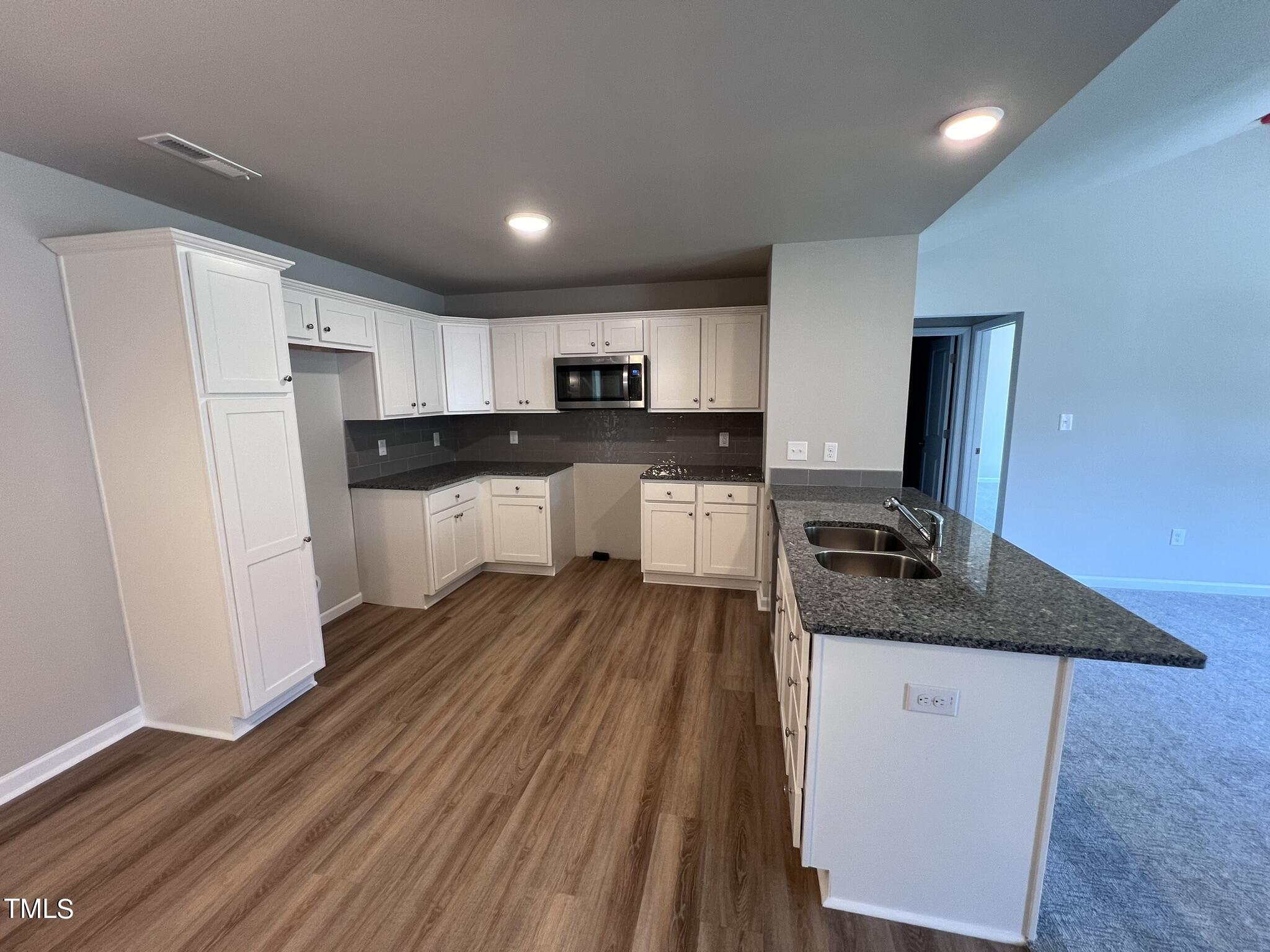 339 Bushel Lane Willow Spring, NC 27592 - Photo 7 of 18 a kitchen with granite countertop a sink stove and refrigerator