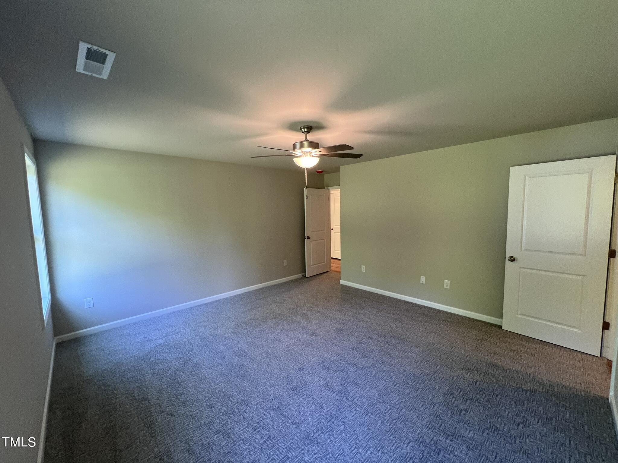 339 Bushel Lane Willow Spring, NC 27592 - Photo 8 of 18 an empty room with a chandelier fan and windows