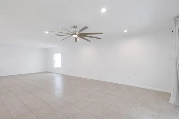an empty room with fan and windows