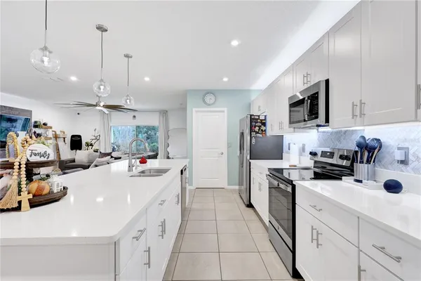 a kitchen with kitchen island a sink stove and refrigerator