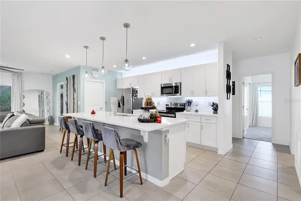 a kitchen with stainless steel appliances kitchen island granite countertop a sink and a refrigerator