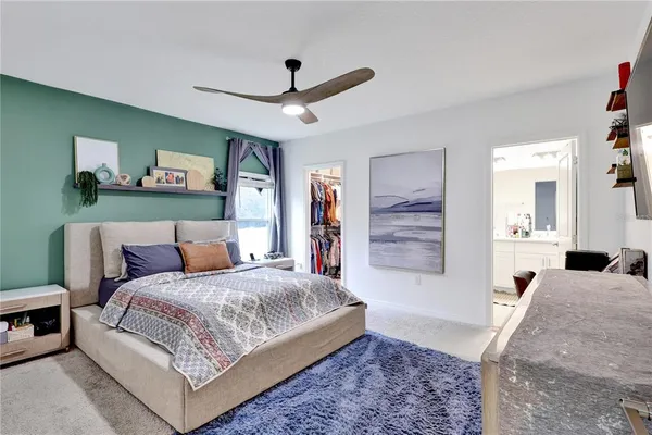 a spacious bedroom with a large bed and a chandelier
