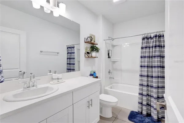 a bathroom with a sink a toilet a shower and a mirror