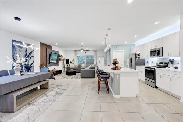 a living room with furniture a view of kitchen and furniture