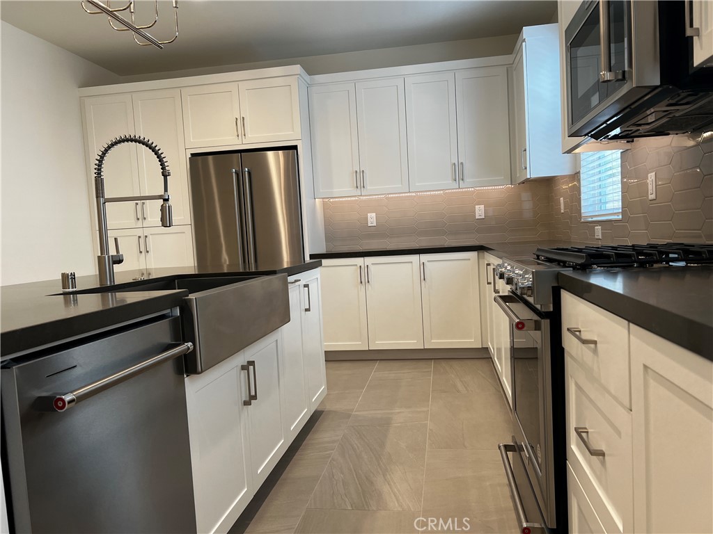 155 Hideaway Loop Mission Viejo, CA 92692 - Photo 6 of 18 a kitchen with granite countertop white cabinets and stainless steel appliances