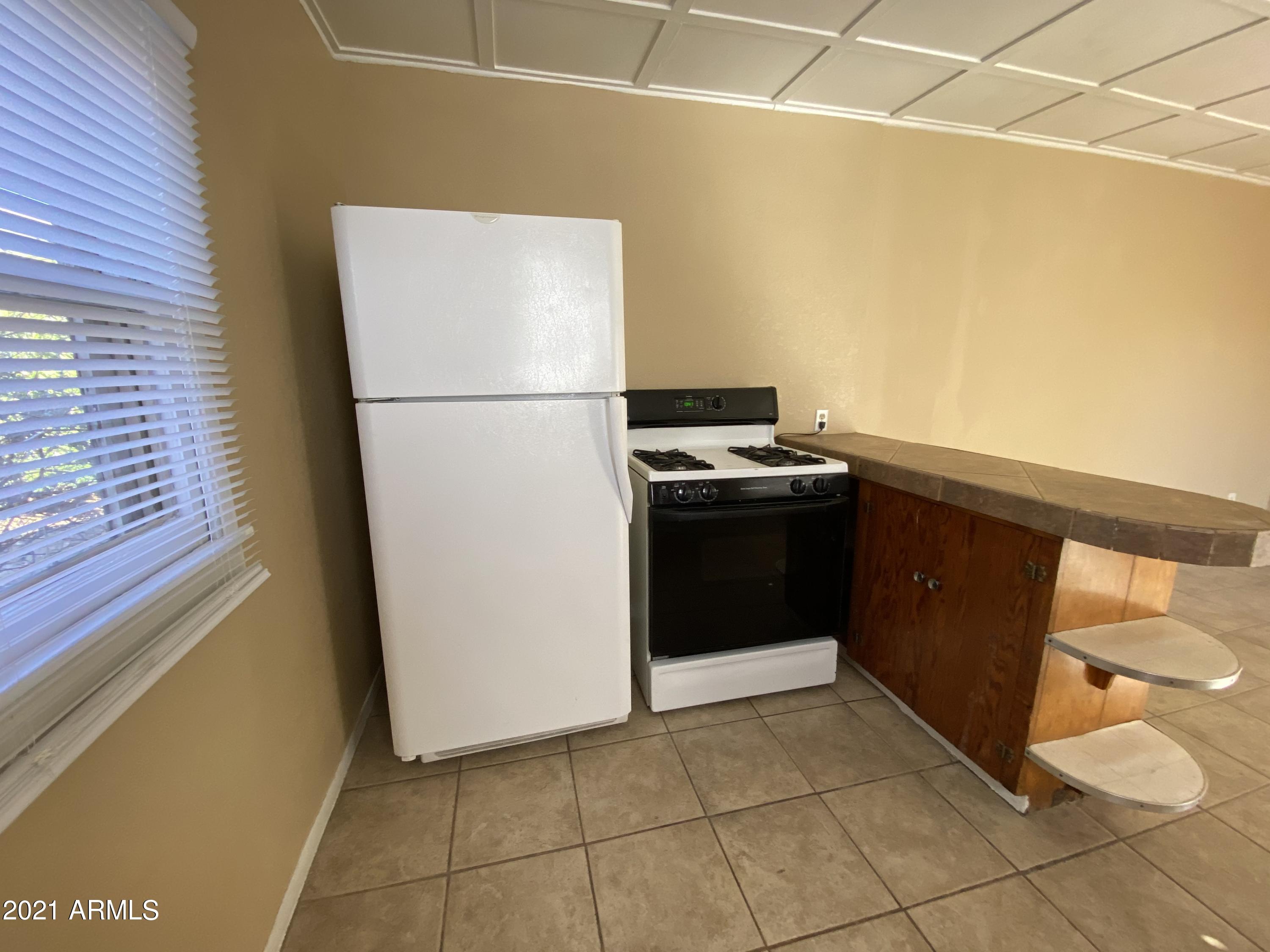 1037 North 25th Street, Unit 2 Phoenix, AZ 85008 - Photo 5 of 18 a kitchen with a refrigerator and a stove