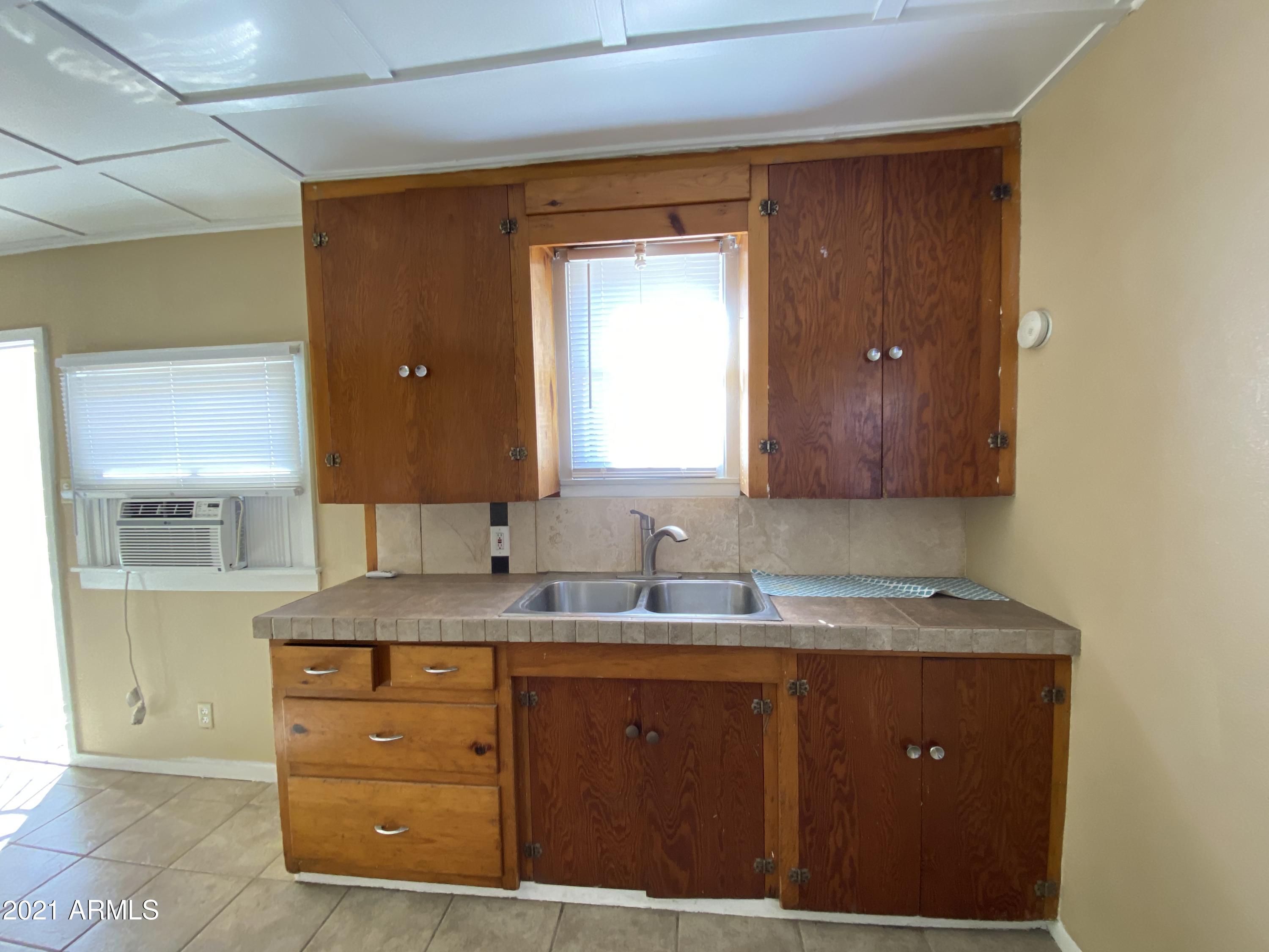 1037 North 25th Street, Unit 2 Phoenix, AZ 85008 - Photo 6 of 18 a bathroom with a granite countertop sink and a mirror