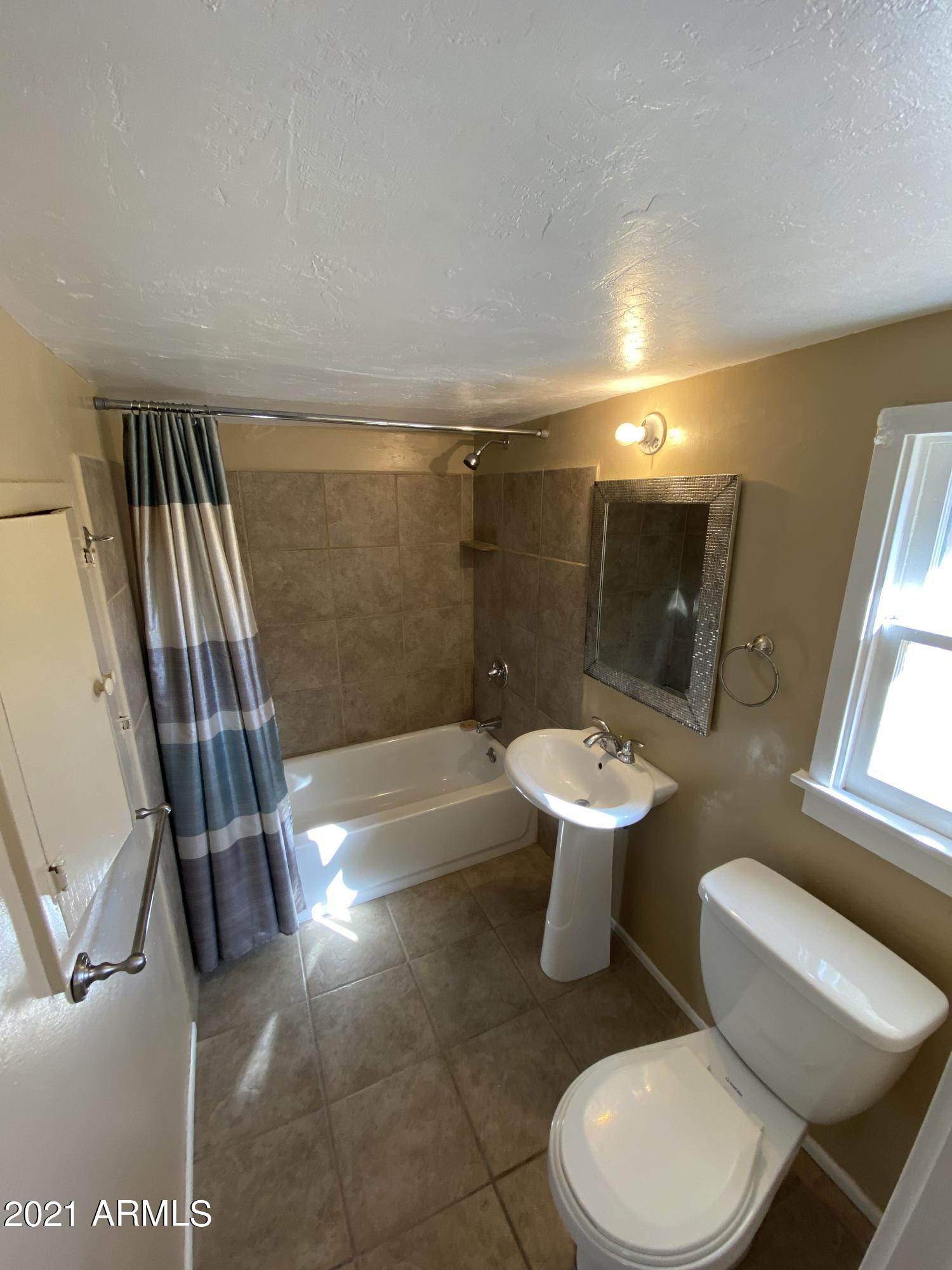 1037 North 25th Street, Unit 2 Phoenix, AZ 85008 - Photo 10 of 18 a bathroom with a sink toilet and shower