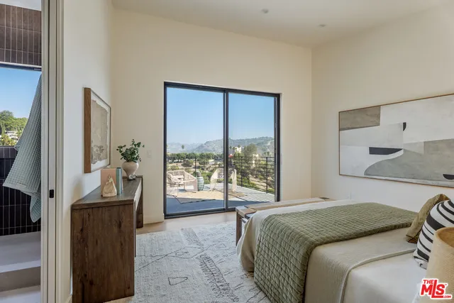a bedroom with a bed and a large window