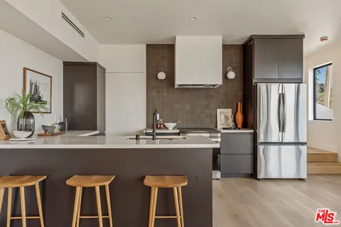 a kitchen with appliances a sink and a refrigerator