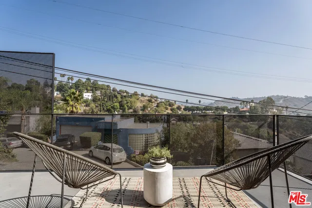 a patio with table and chairs and potted plants