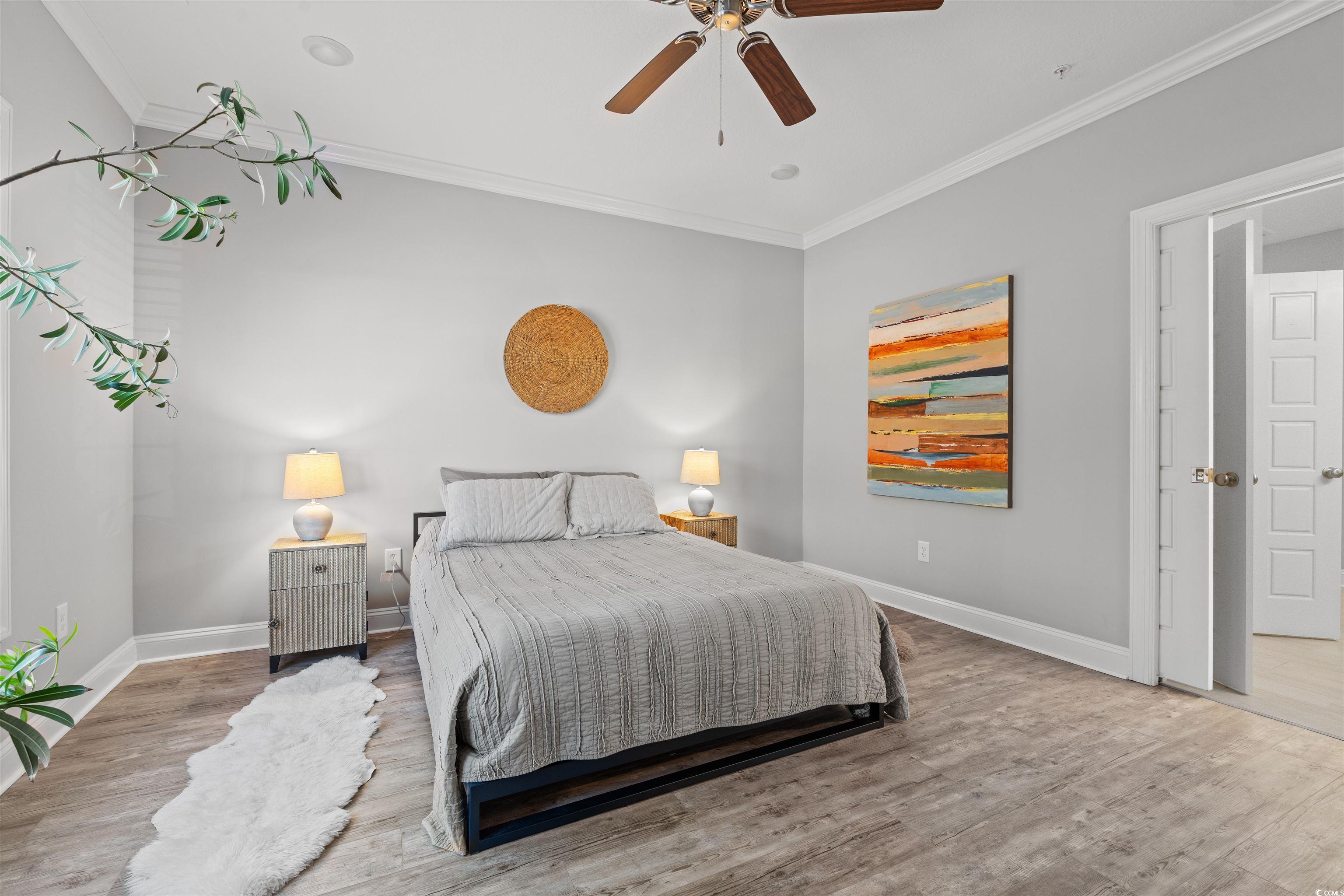 933 Jackline Place, Unit 101 Murrells Inlet, SC 29576 - Photo 8 of 35 Bedroom with ceiling fan, ornamental molding, wood