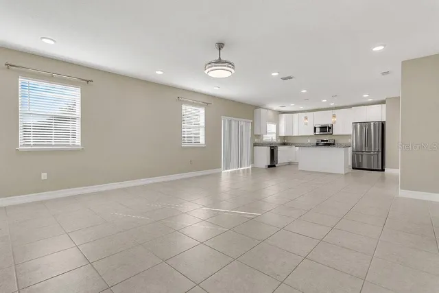 a kitchen with stainless steel appliances granite countertop a refrigerator and a stove top oven