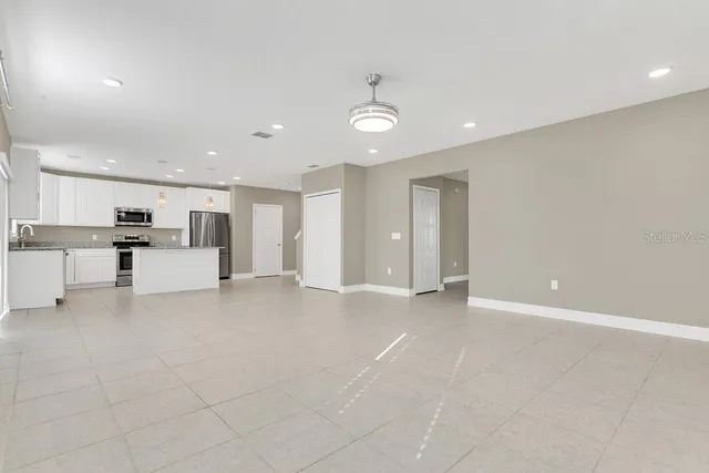 a kitchen with granite countertop white cabinets and stainless steel appliances