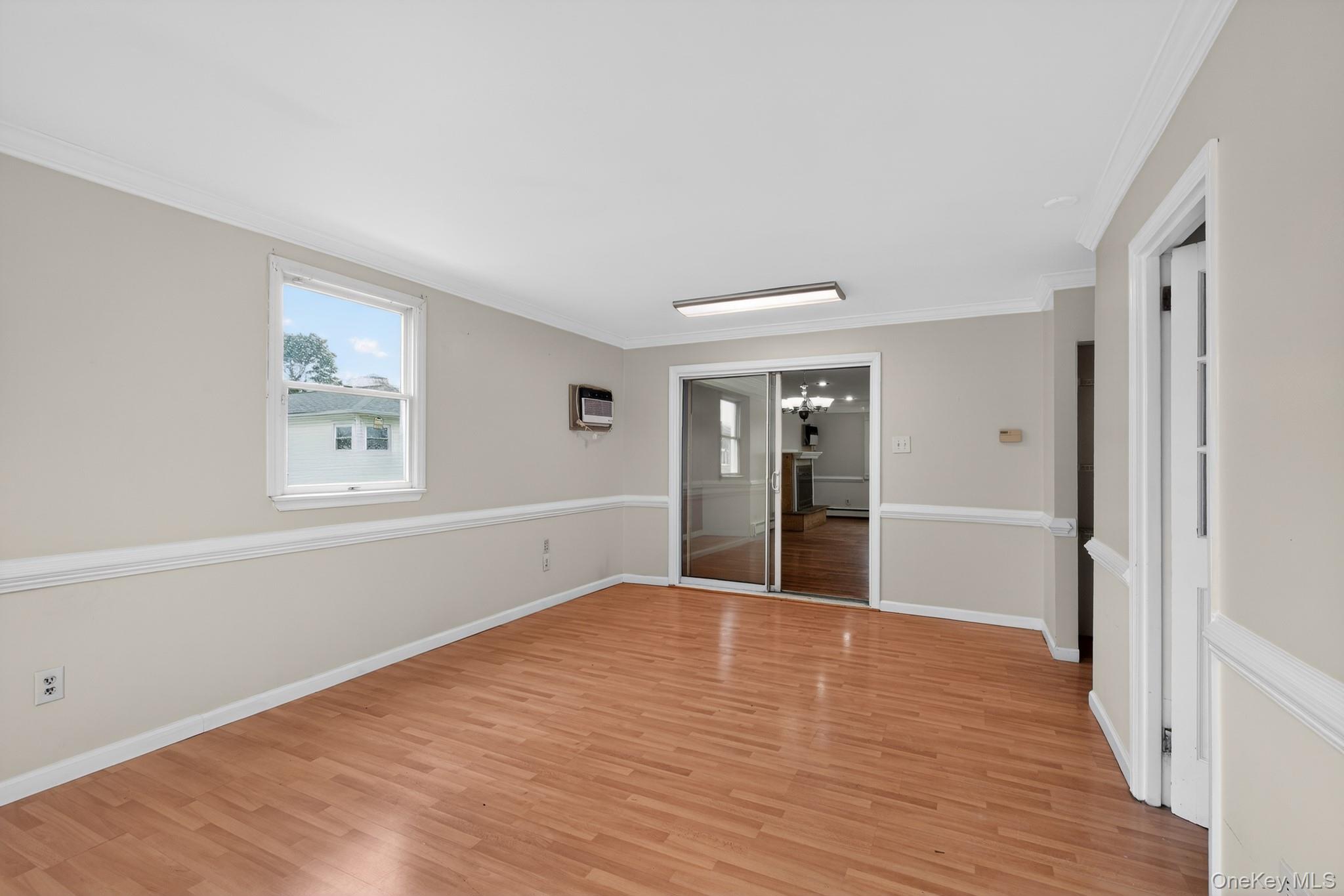 138 Spring Street Massapequa, NY 11758 - Photo 15 of 45 a view of an empty room with wooden floor and a window
