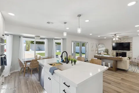 a view of a dining room with furniture a kitchen and chandelier
