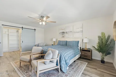 a bedroom with a bed a mirror and a flat tv screen on dresser