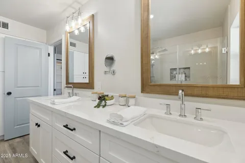 a spacious bathroom with a double vanity sink and mirror