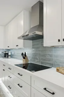 a large white kitchen with a table and chairs