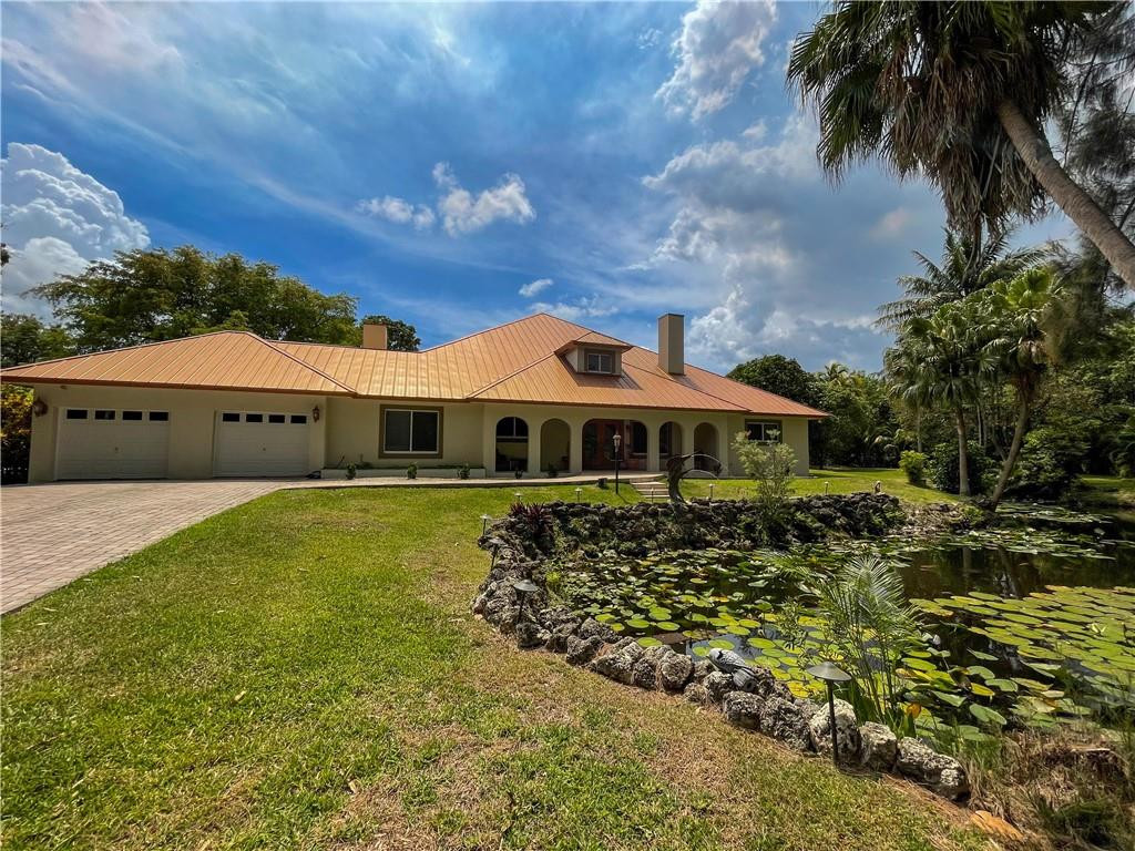 12990 Southwest 56th Street Southwest Ranches, FL 33330 - Photo 2 of 62 a front view of a house with a garden