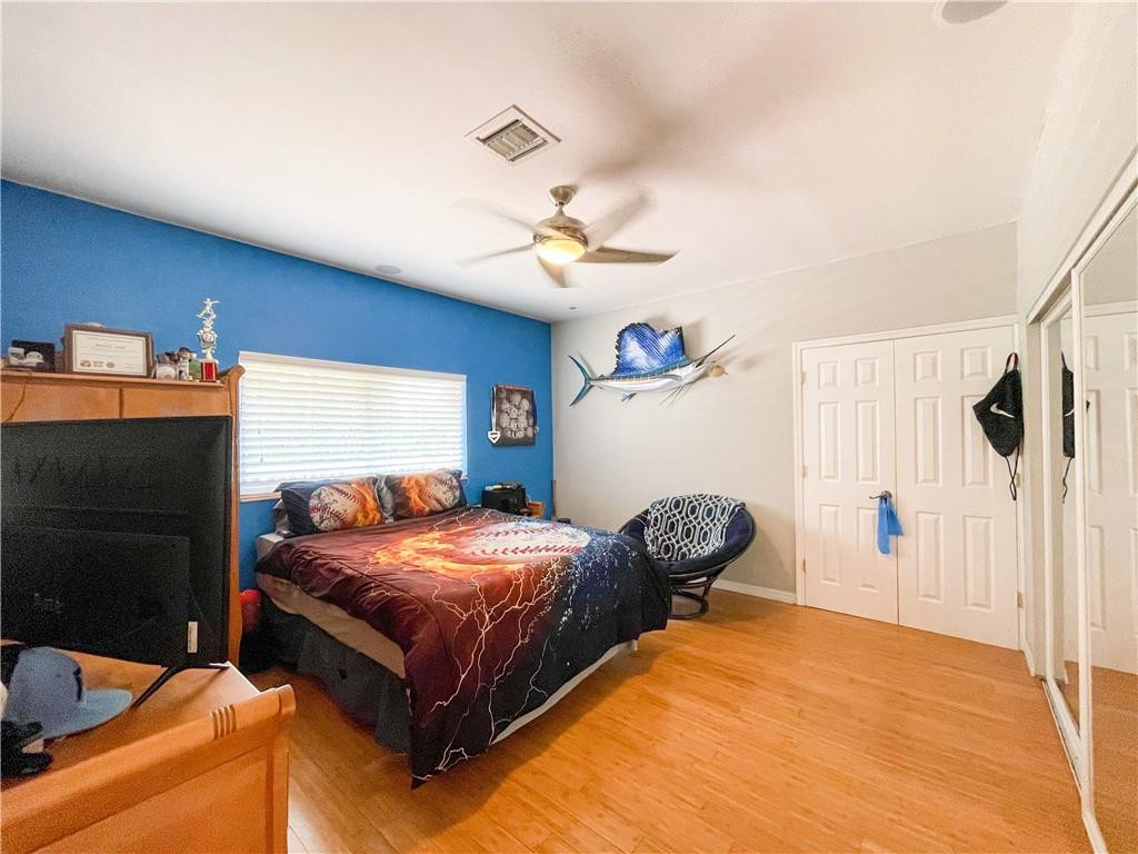 12990 Southwest 56th Street Southwest Ranches, FL 33330 - Photo 52 of 62 a bedroom with a bed and a chandelier