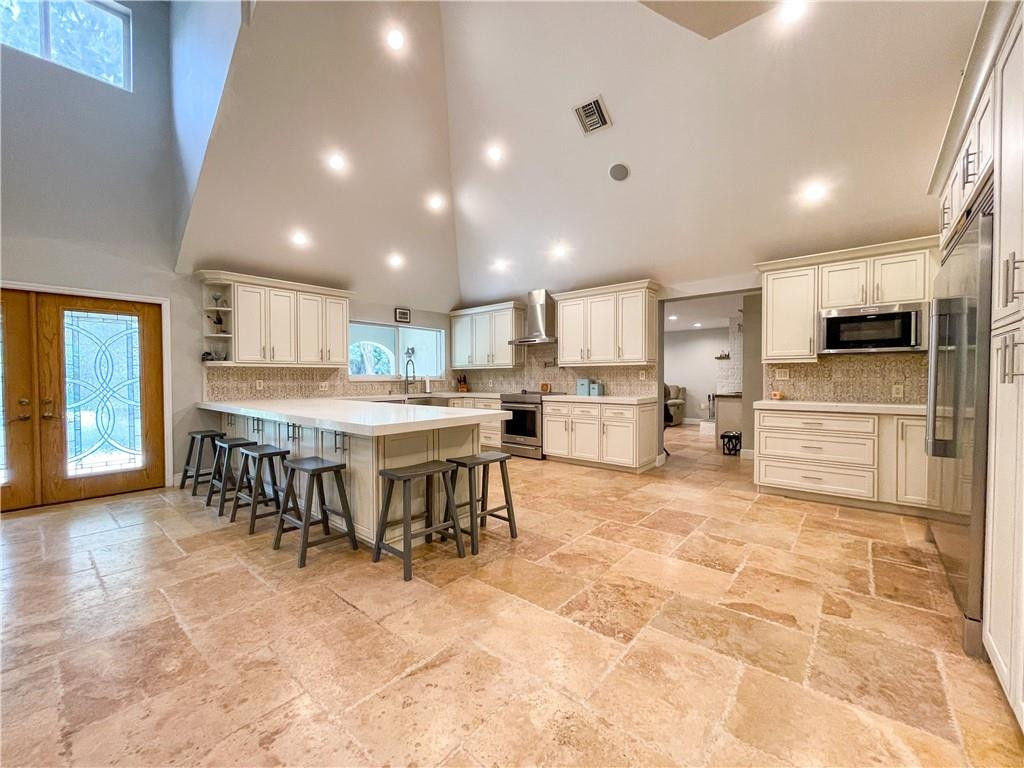 12990 Southwest 56th Street Southwest Ranches, FL 33330 - Photo 8 of 62 a kitchen with kitchen island a stove a table and chairs in it