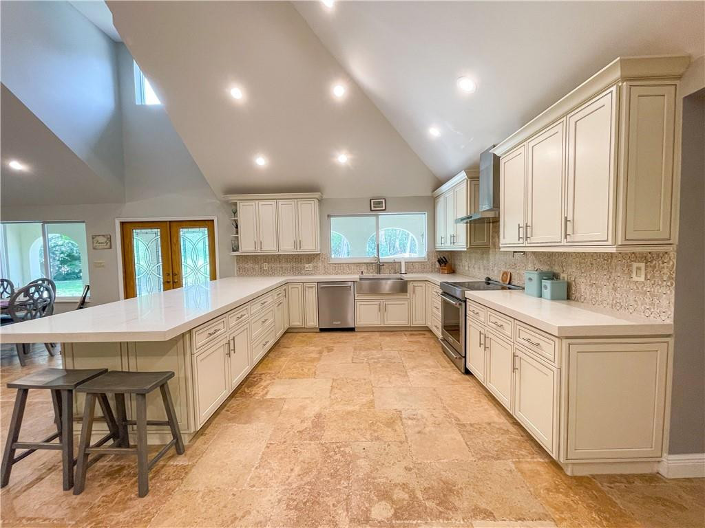 12990 Southwest 56th Street Southwest Ranches, FL 33330 - Photo 10 of 62 a large kitchen with stainless steel appliances granite countertop a large counter top a stove a sink dishwasher and a refrigerator with wooden floor