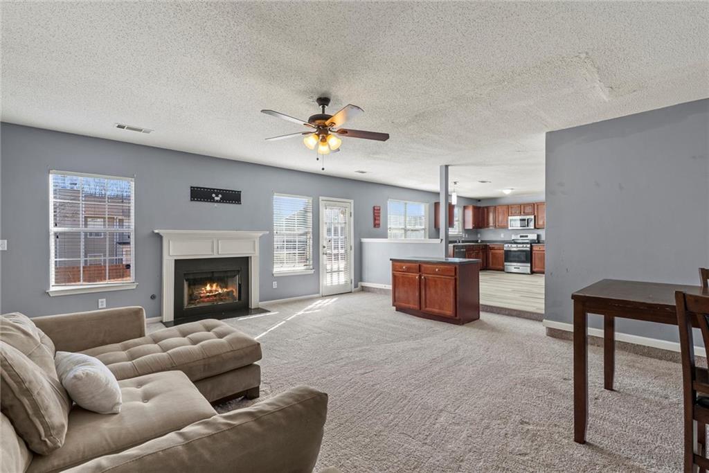 541 Hamlet Drive Hampton, GA 30228 - Photo 13 of 53 a living room with furniture kitchen view and a fireplace