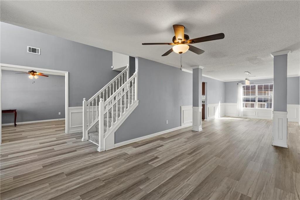 541 Hamlet Drive Hampton, GA 30228 - Photo 25 of 53 a view of a livingroom with wooden floor a ceiling fan and staircase