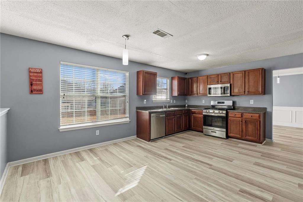 541 Hamlet Drive Hampton, GA 30228 - Photo 40 of 53 a kitchen with stainless steel appliances granite countertop a stove sink and cabinets
