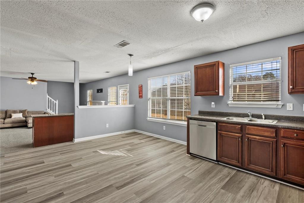 541 Hamlet Drive Hampton, GA 30228 - Photo 10 of 53 a kitchen with stainless steel appliances granite countertop a sink dishwasher stove and wooden cabinets