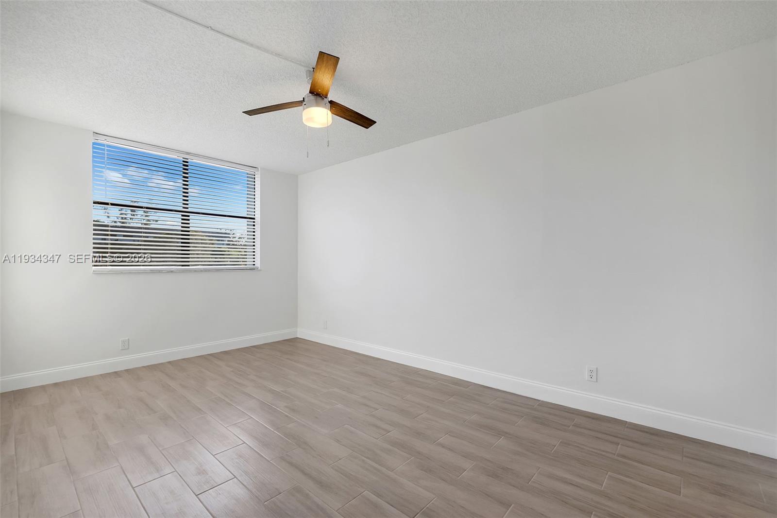 2501 Riverside Drive, Unit 307A Coral Springs, FL 33065 - Photo 6 of 28 a view of an empty room with wooden floor and a window