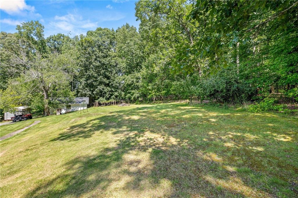 6470 Samoa Way Flowery Branch, GA 30542 - Photo 56 of 61 a view of outdoor space with a garden and trees