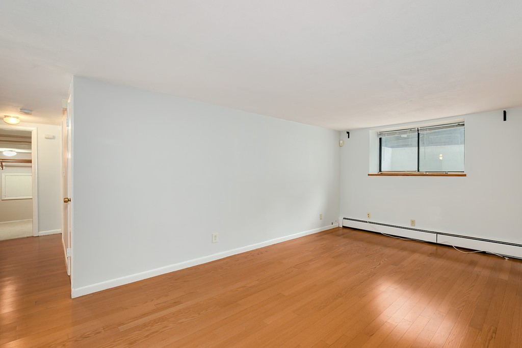 116 Sutherland Road, Unit 2A Boston, MA 02135 - Photo 5 of 14 an empty room with wooden floor and windows