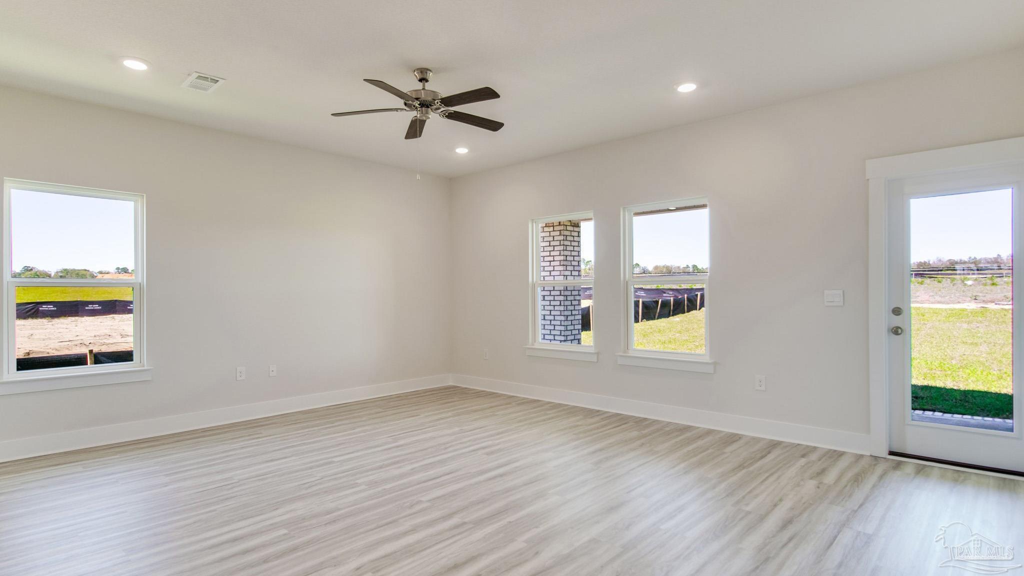 2733 Chevy Circle Pace, FL 32571 - Photo 16 of 37 a view of an empty room with a window and wooden floor