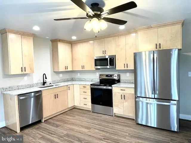 a kitchen with stainless steel appliances a refrigerator sink and microwave