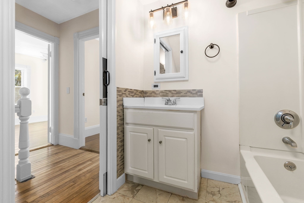 14 1/2 Hampshire Street Danvers, MA 01923 - Photo 21 of 37 a bathroom with a sink a mirror and a bathtub