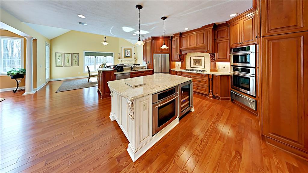 811 Mt Pleasant Road Mars, PA 16046 - Photo 8 of 25 a kitchen with stainless steel appliances granite countertop a refrigerator a oven a dining table and chairs with wooden floor