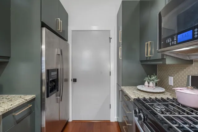 a kitchen with stainless steel appliances granite countertop a stove refrigerator and cabinets