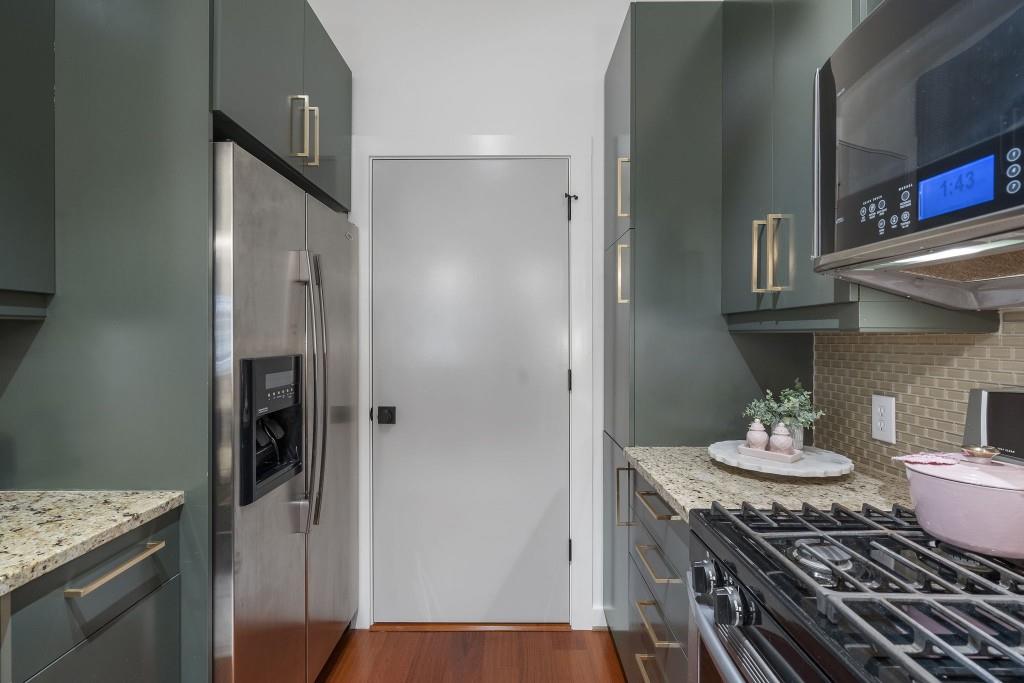 870 Inman Vlg Parkway Northeast, Unit 212 Atlanta, GA 30307 - Photo 11 of 23 a kitchen with stainless steel appliances granite countertop a stove refrigerator and cabinets