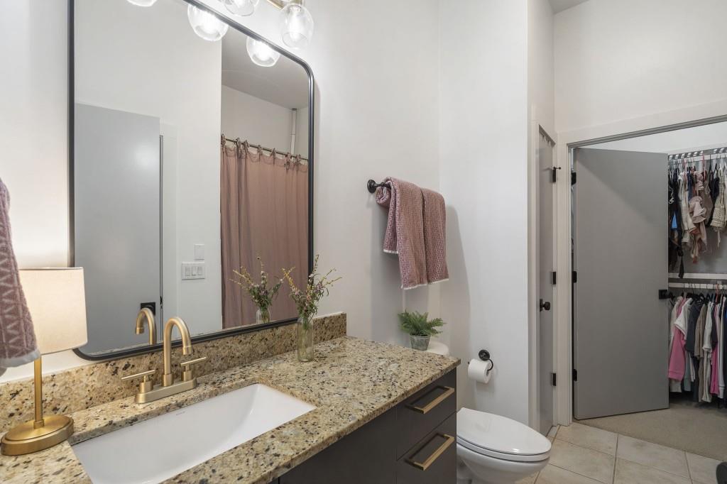 870 Inman Vlg Parkway Northeast, Unit 212 Atlanta, GA 30307 - Photo 16 of 23 a bathroom with a granite countertop sink toilet and shower
