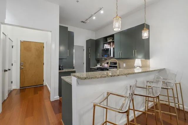 a kitchen with stainless steel appliances granite countertop a sink and a refrigerator