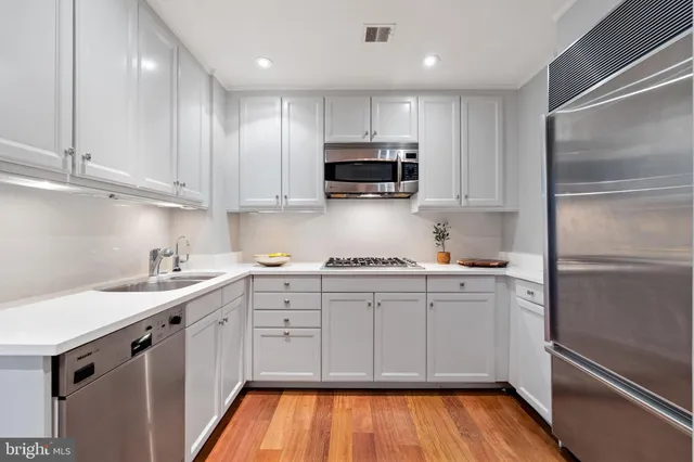a kitchen with white cabinets and stainless steel appliances