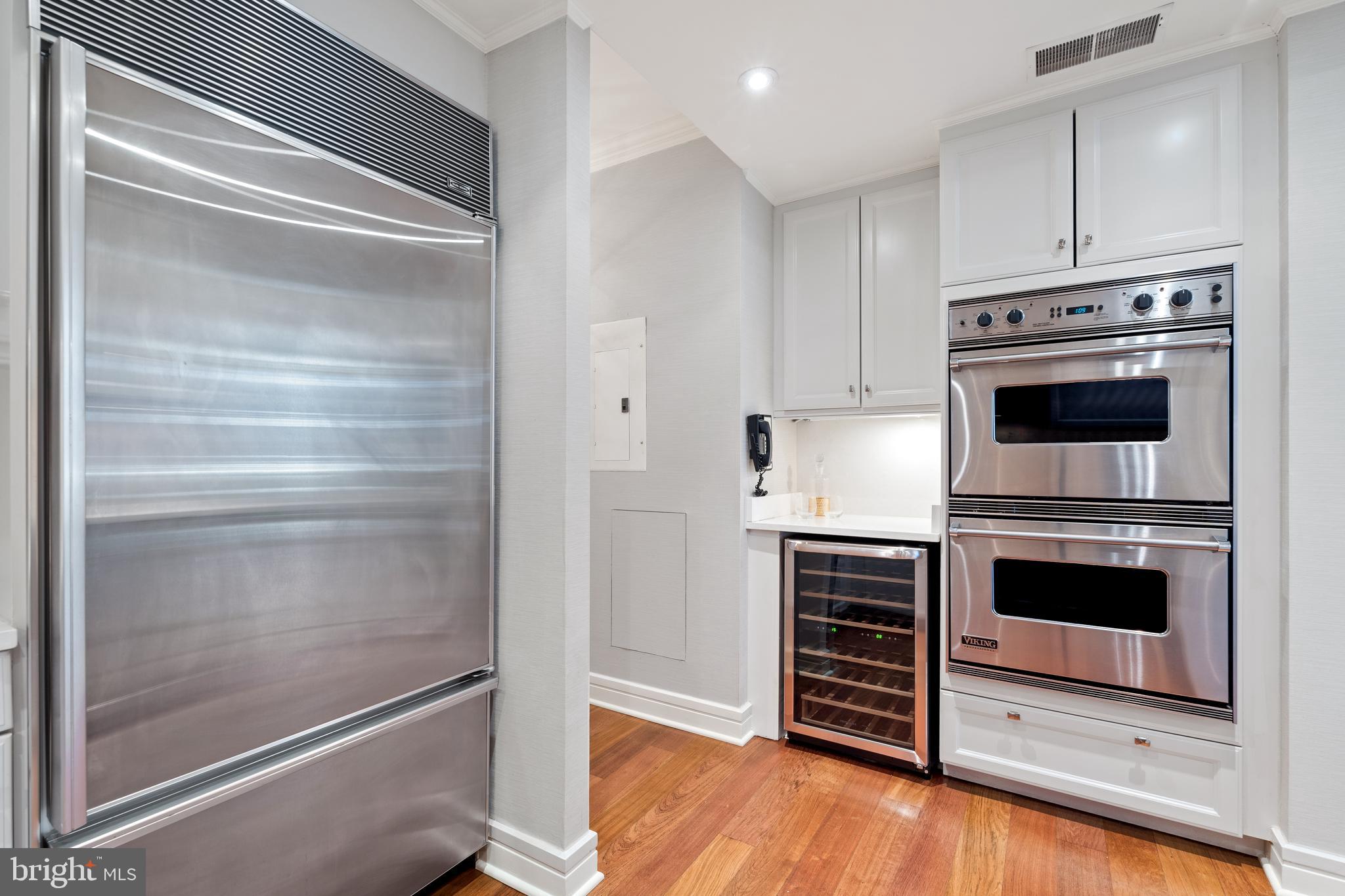1111 23rd Street Northwest, Unit 4C Washington, DC 20037 - Photo 21 of 39 a kitchen with white cabinets and stainless steel appliances