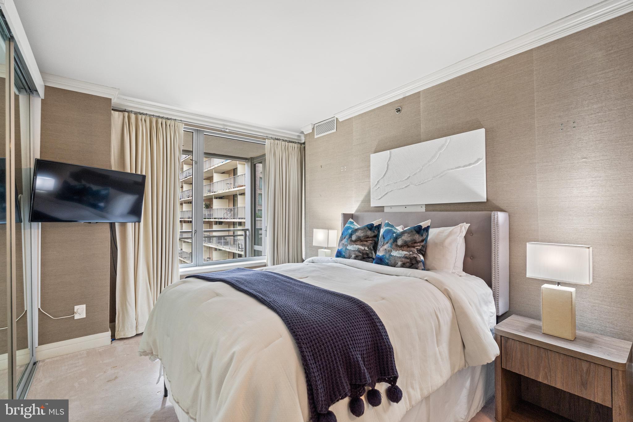 1111 23rd Street Northwest, Unit 4C Washington, DC 20037 - Photo 29 of 39 a bedroom with a bed and a flat screen tv