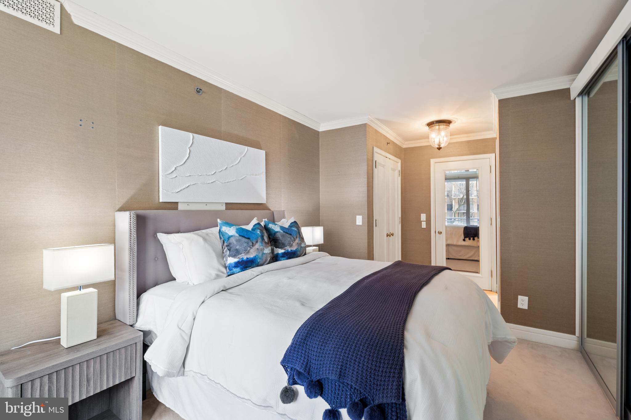 1111 23rd Street Northwest, Unit 4C Washington, DC 20037 - Photo 30 of 39 a bedroom with a bed and a lamp