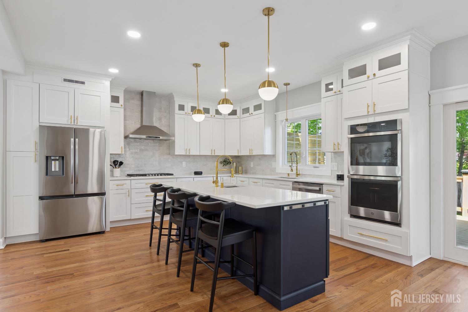 831 West Inman Avenue Rahway, NJ 07065 - Photo 5 of 35 a kitchen with stainless steel appliances granite countertop a refrigerator a sink dishwasher a kitchen island and chairs with wooden floor