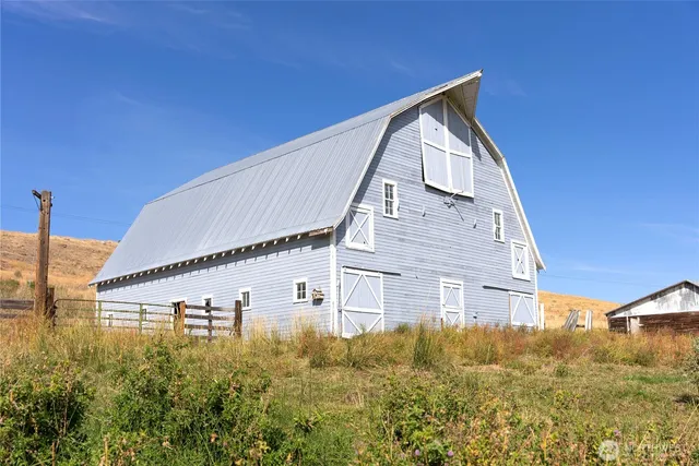 a view of a big house with wooden fence