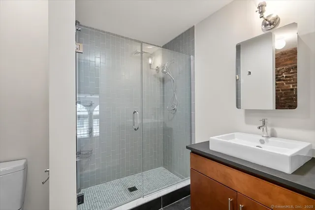 a bathroom with a shower sink and mirror