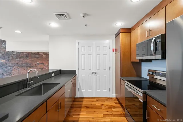 a kitchen with stainless steel appliances a sink stove and refrigerator